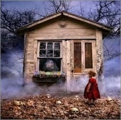 Image shows child standing in front of a haunted house.